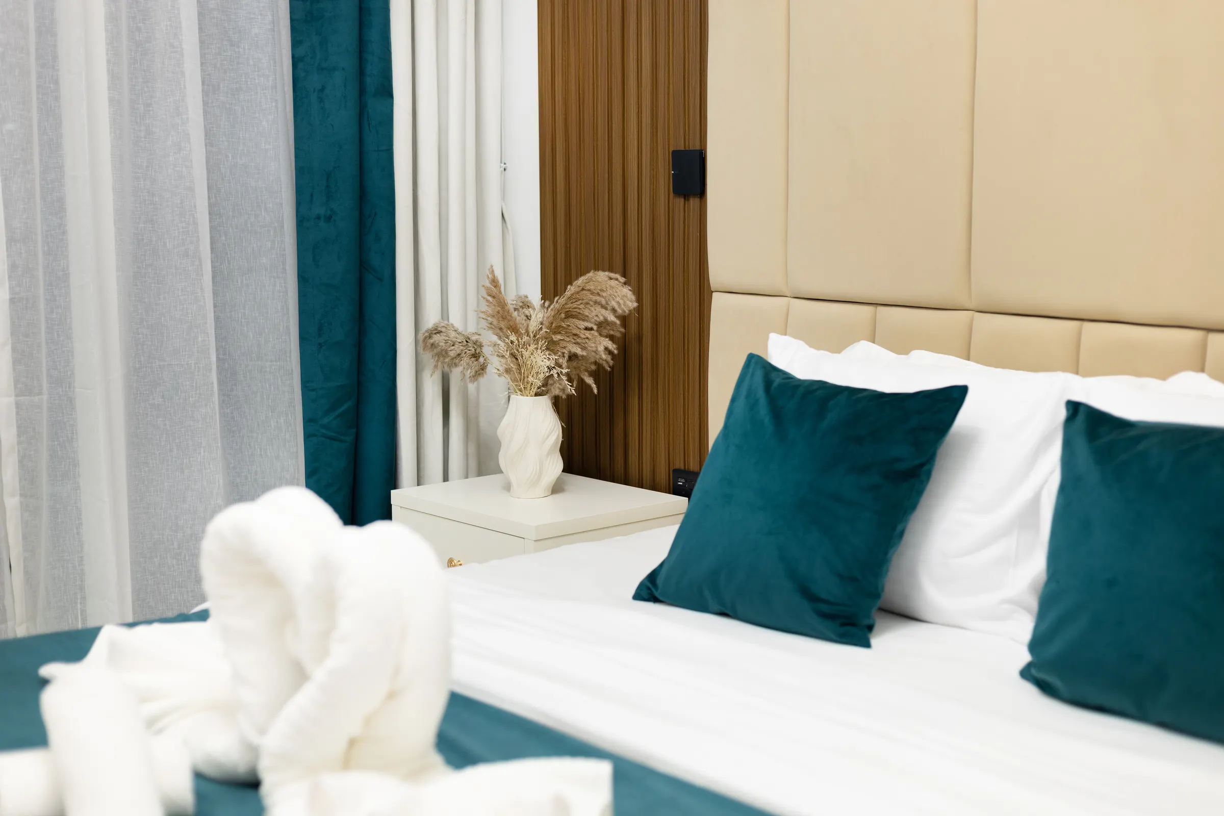 Teal velvet cushions and dried pampas beside the bed — Opalz by Danube, Arjan